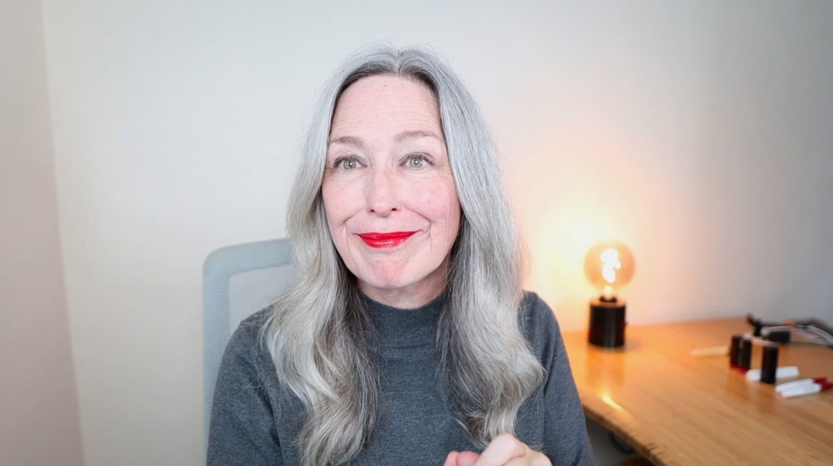 image of woman with grey hair wearing Aveda Goji lipstick