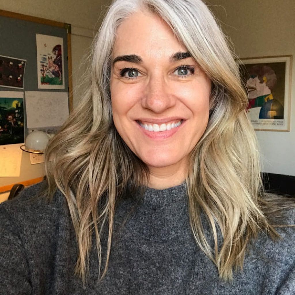 image of white woman gray roots blonde ends transitioning to grey hair with highlights