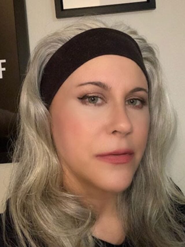 woman with black headband gray hair and red lipstick