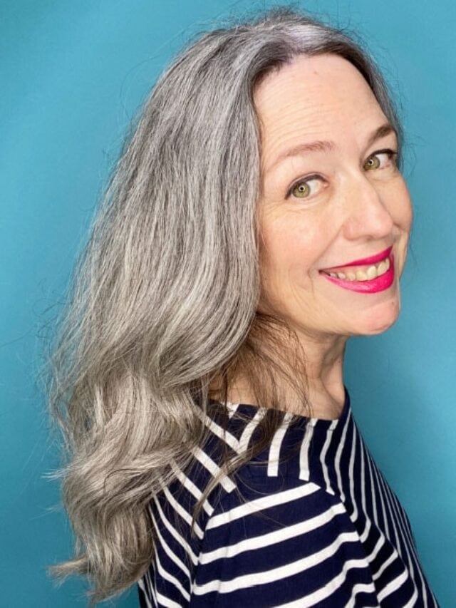 image of woman with long gray hair with text that says 7 surprising benefits of going gray