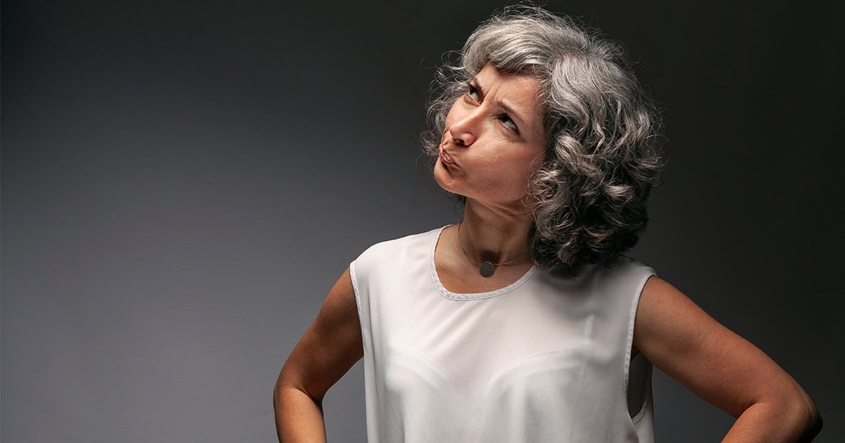 woman with gray curly bobbed hair looking puzzled