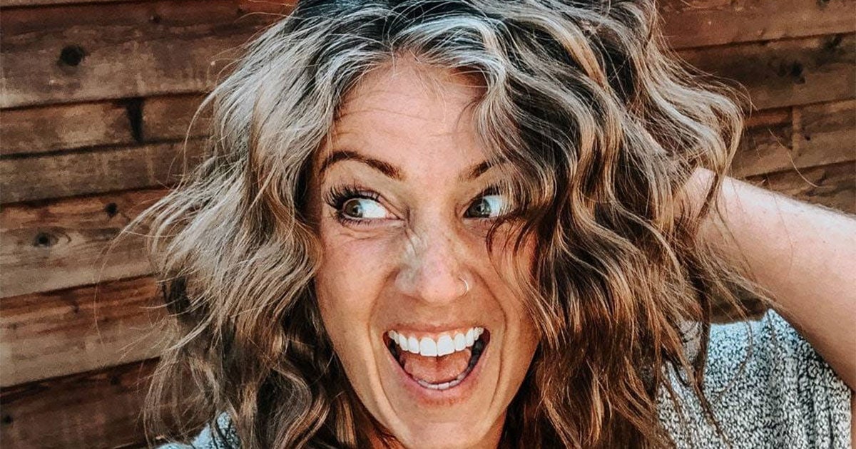 close up image of young woman with graying hair, smiling