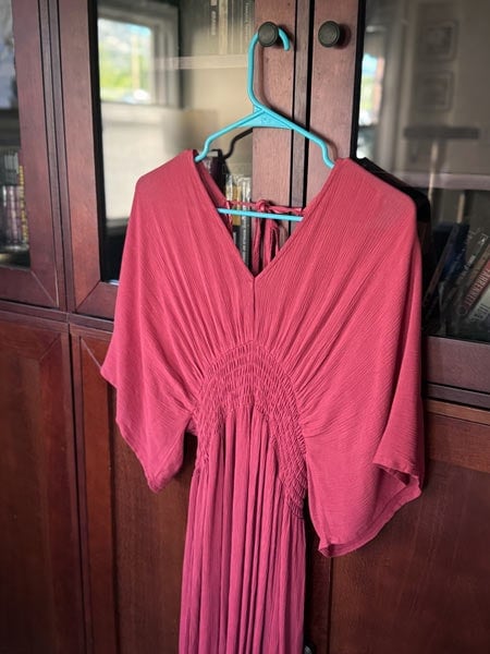 image of a salmon-colored dress hanging on a hanger