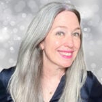 image of woman with bright gray hair against a sparkly background