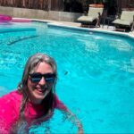 image of woman with gray hair and pink swimshirt swimming in pool