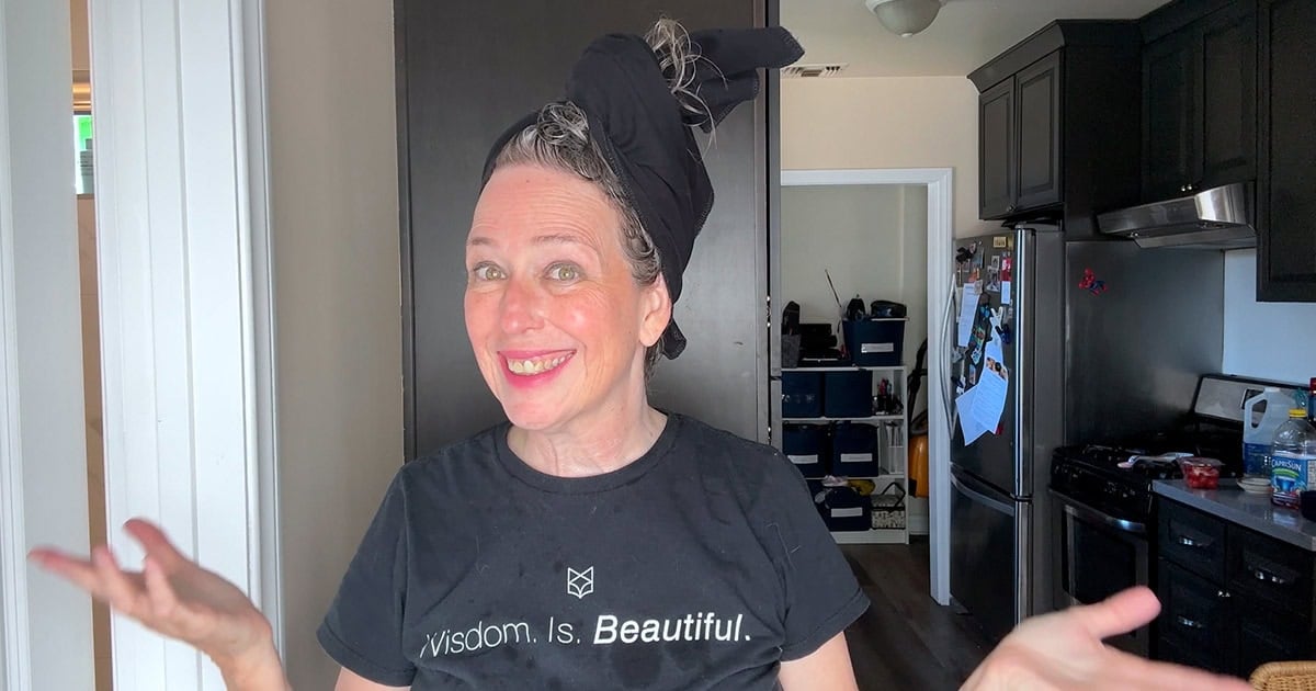 image of gray hair woman smiling with hair wrapped in t-shirt towel