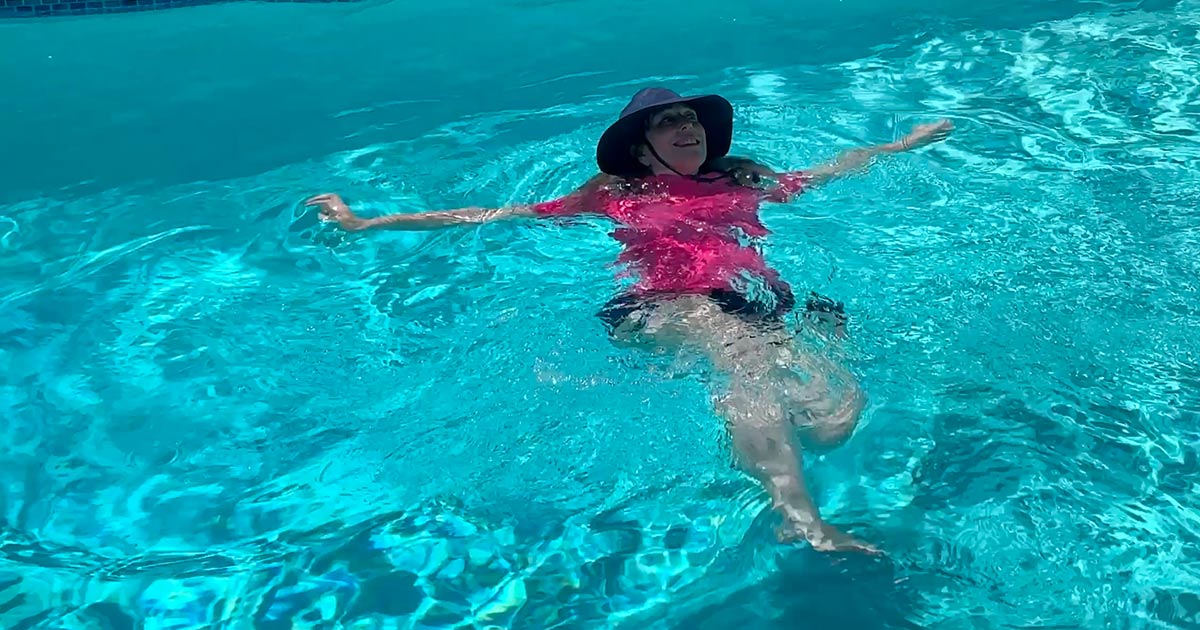 image of gray hair woman swimming with Aqua Hat