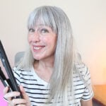 image of Katie with sleek hair smiling and holding paul mitchell neuro flat iron