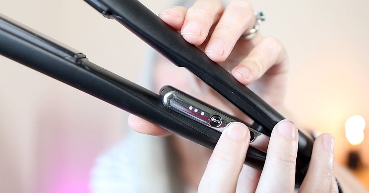 image of katie's hands adjusting temperature to medium on the flat iron